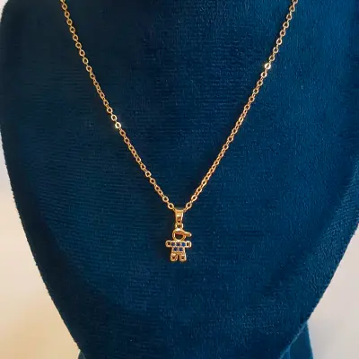 colar com pingente de boneco dourado com detalhes azuis
