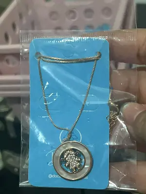 colar com pingente redondo e detalhe de menina com pedras