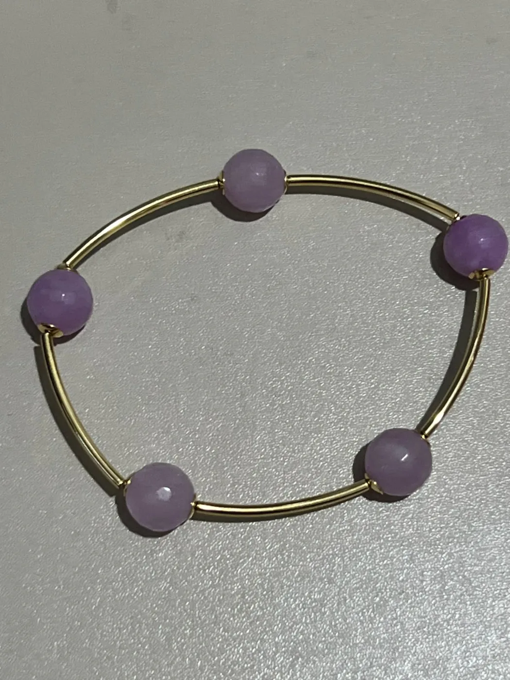 pulseira com pedras roxas e tubos dourados