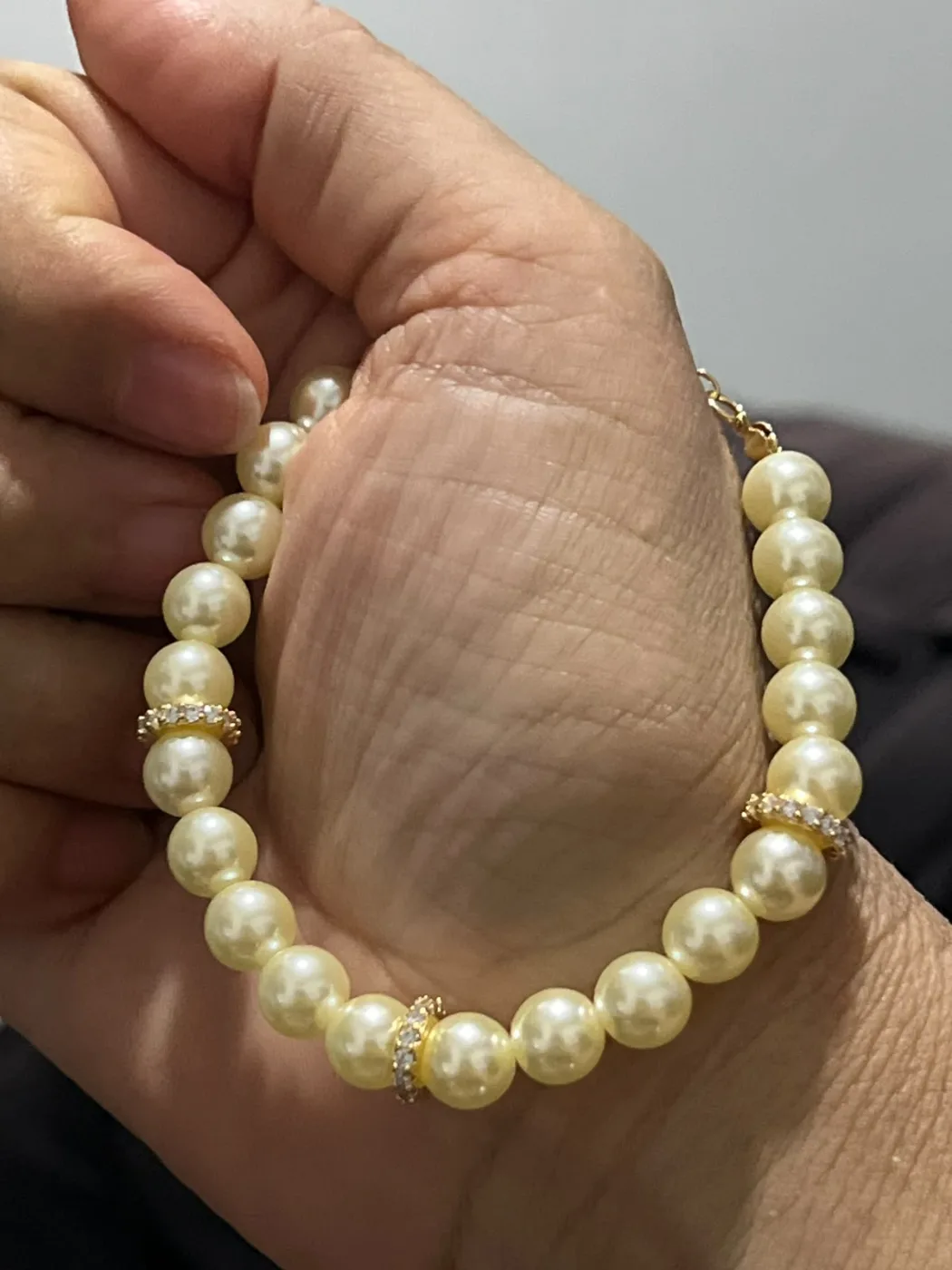 pulseira de pérolas com detalhes dourados e strass
