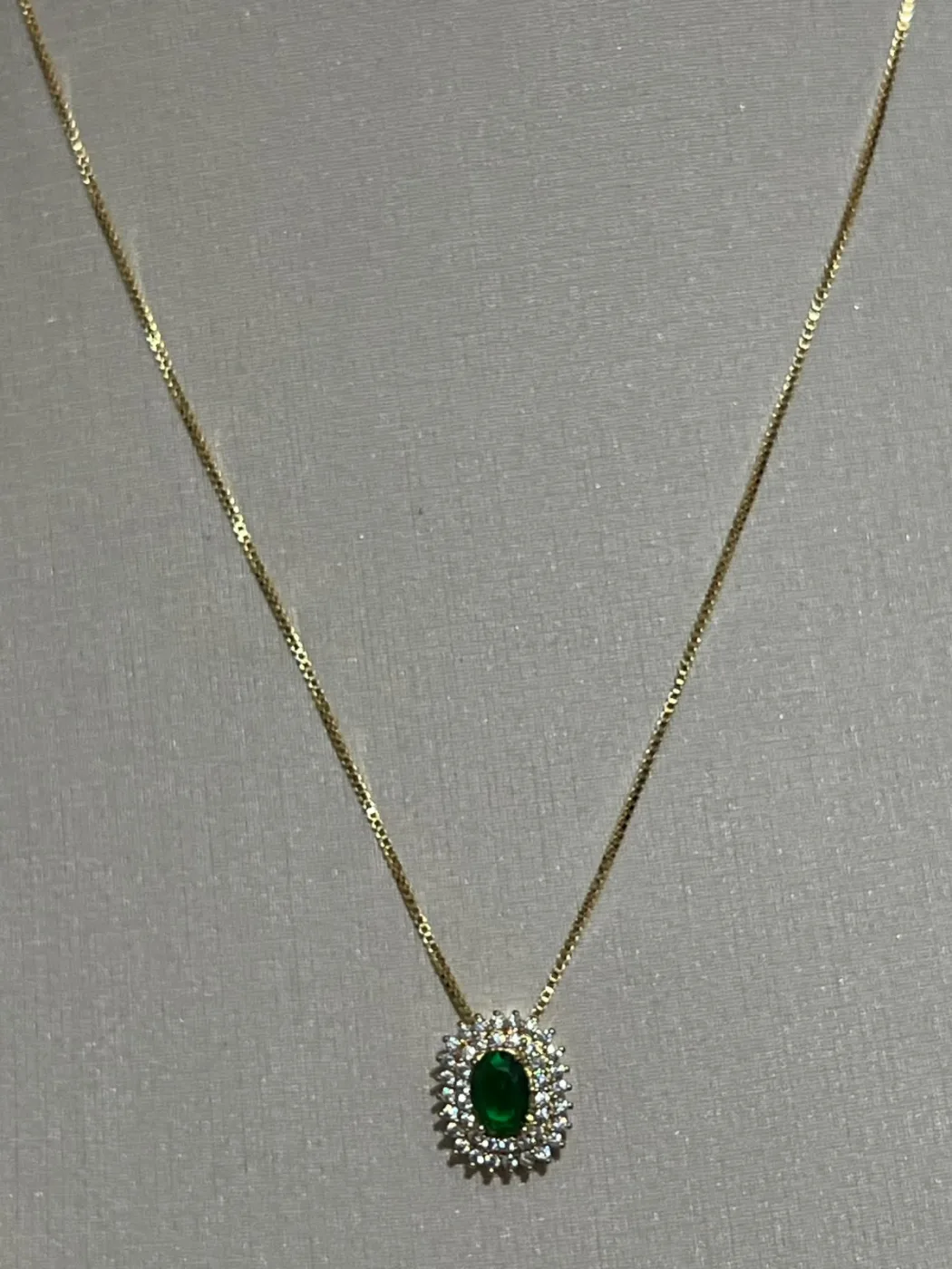 colar com pingente oval verde e pedras ao redor