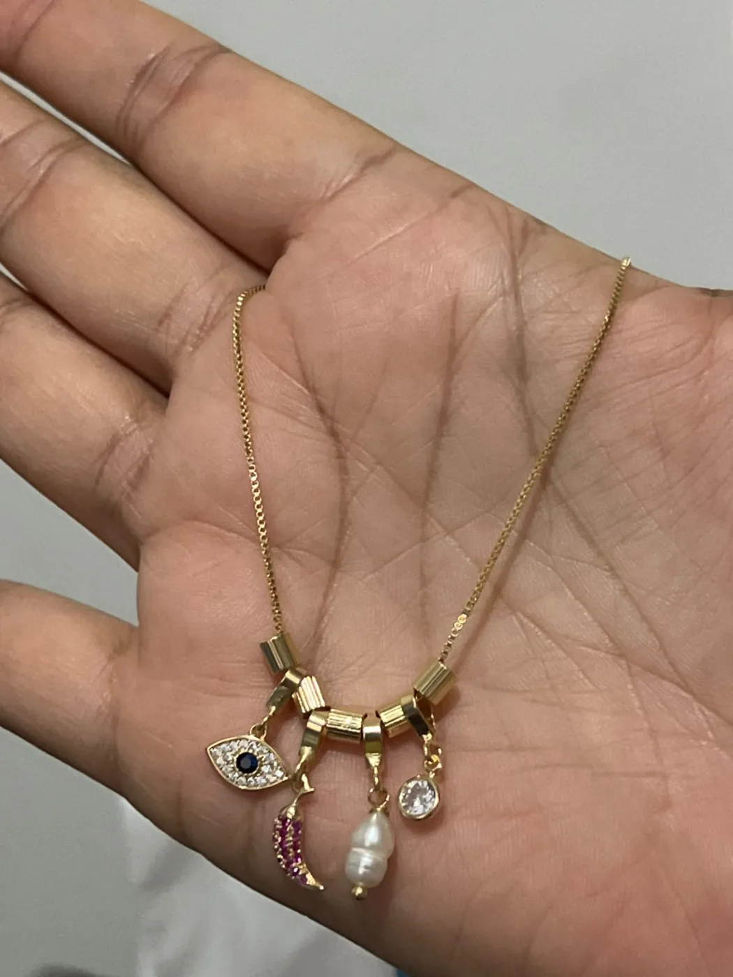 colar com pingentes variados de olho, lua, pérola e pedra