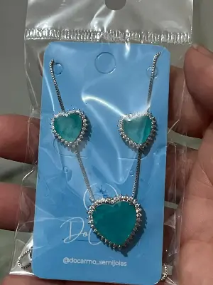 conjunto de colar e brincos com coração verde e pedras ao redor