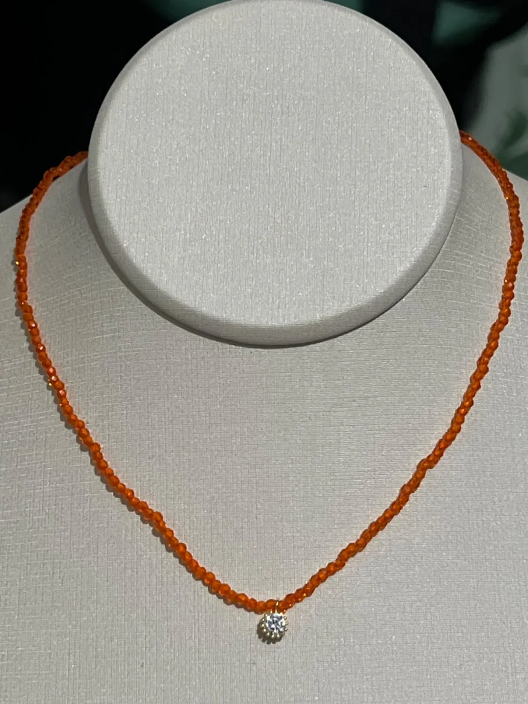 colar com miçangas laranja e pingente de pedra branca