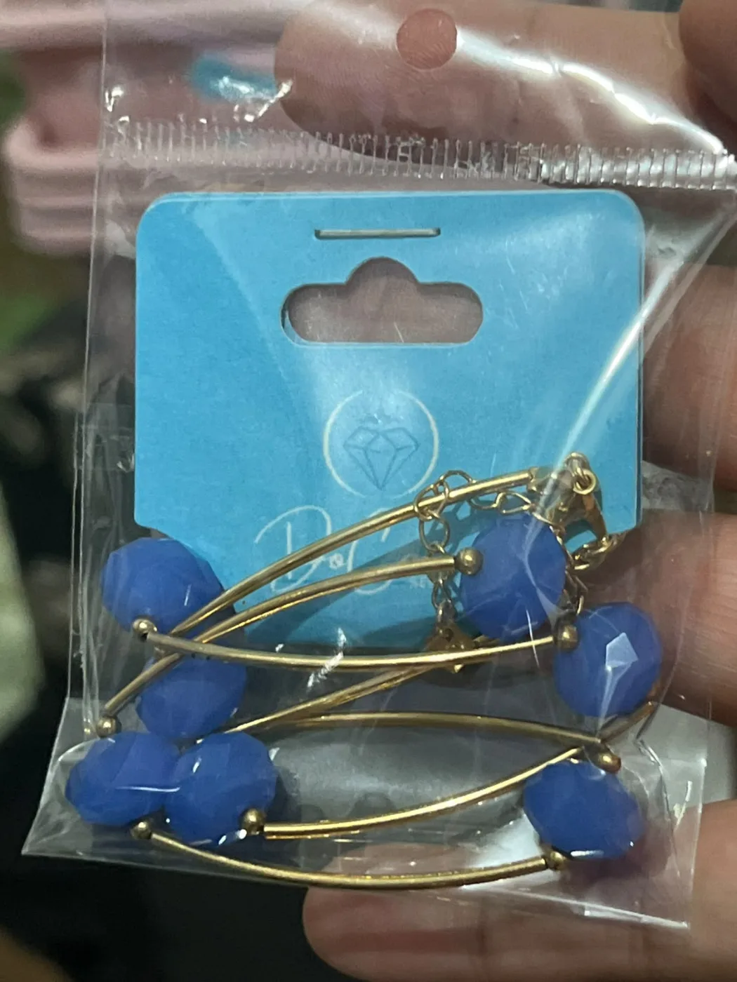 Colar com contas azuis facetadas e estrutura dourada