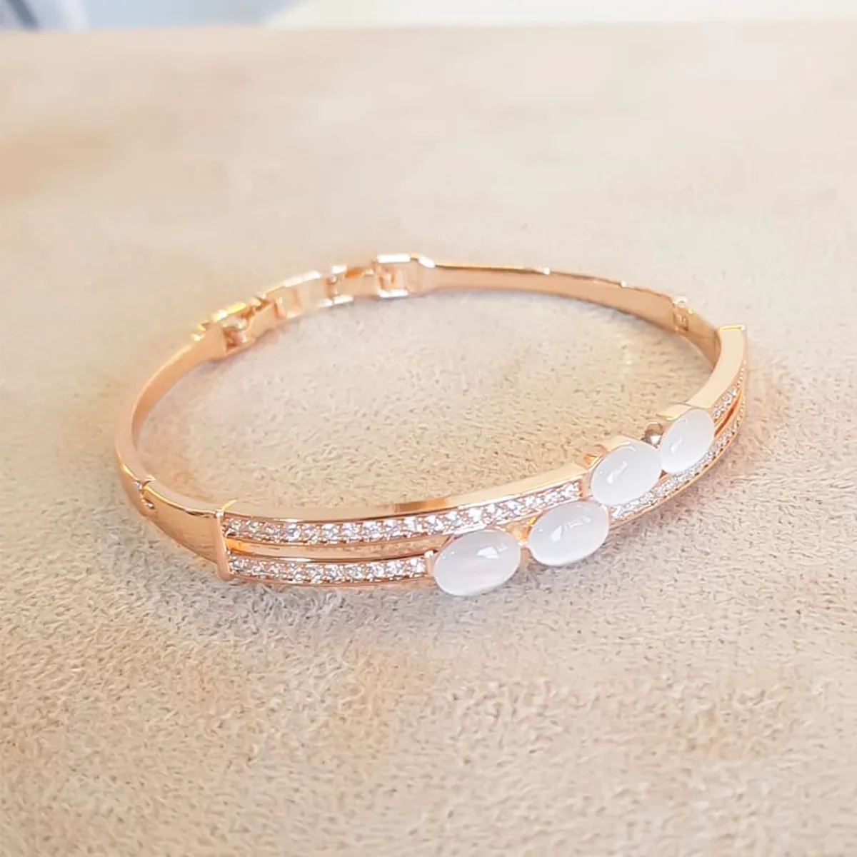 pulseira rígida com pedras brancas e detalhes em strass