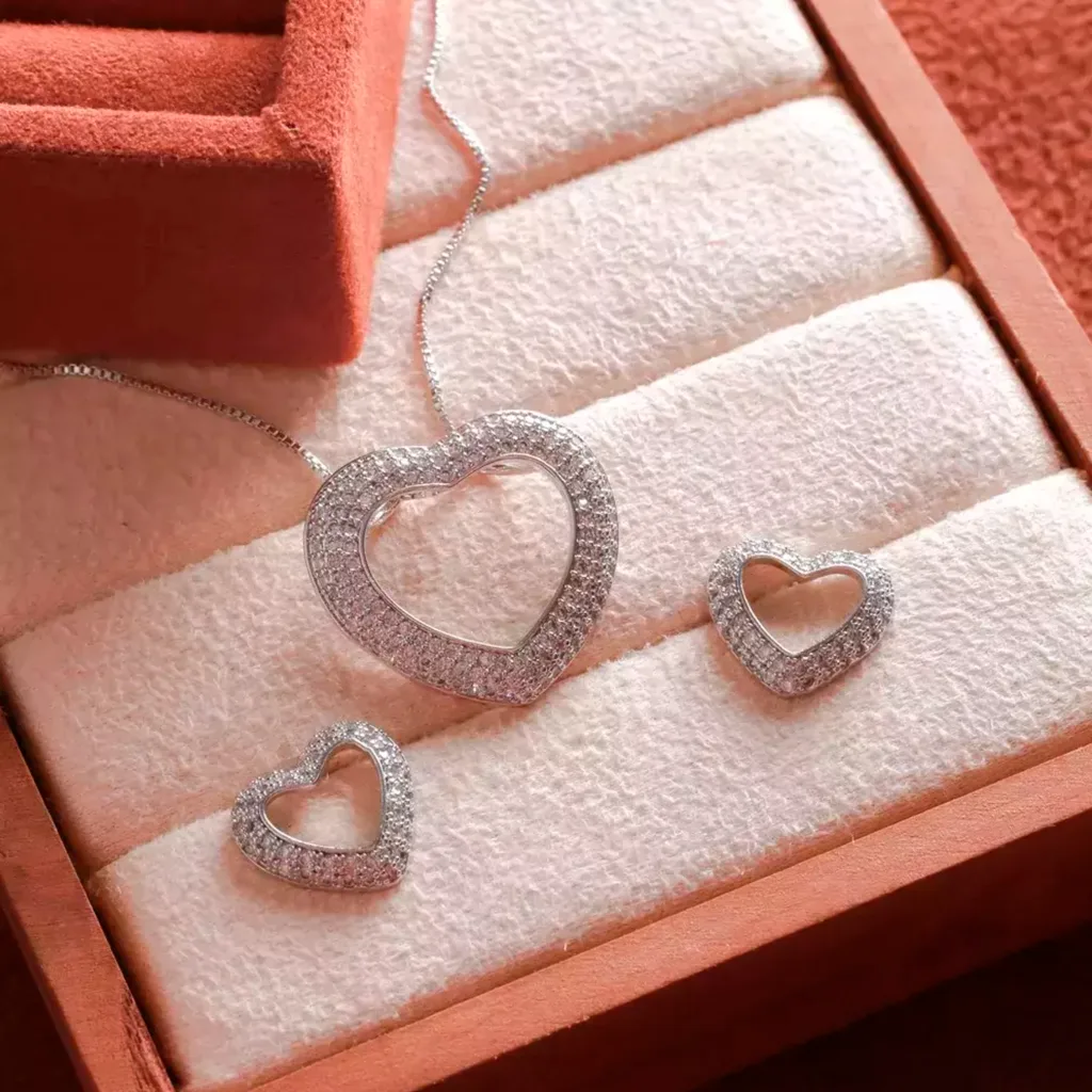 CONJUNTO DE CORAÇÃO VAZADO CRAVEJADO DE ZIRCÔNIAS CRISTAIS - RÓDIO BRANCO (45CM+5CM)