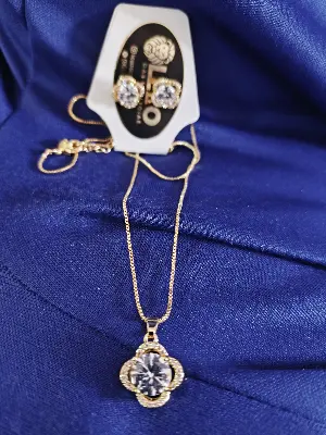 conjunto colar e brinco com pedra central redonda e detalhes dourados