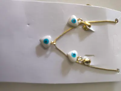brincos com pingentes de olho grego em formato triangular